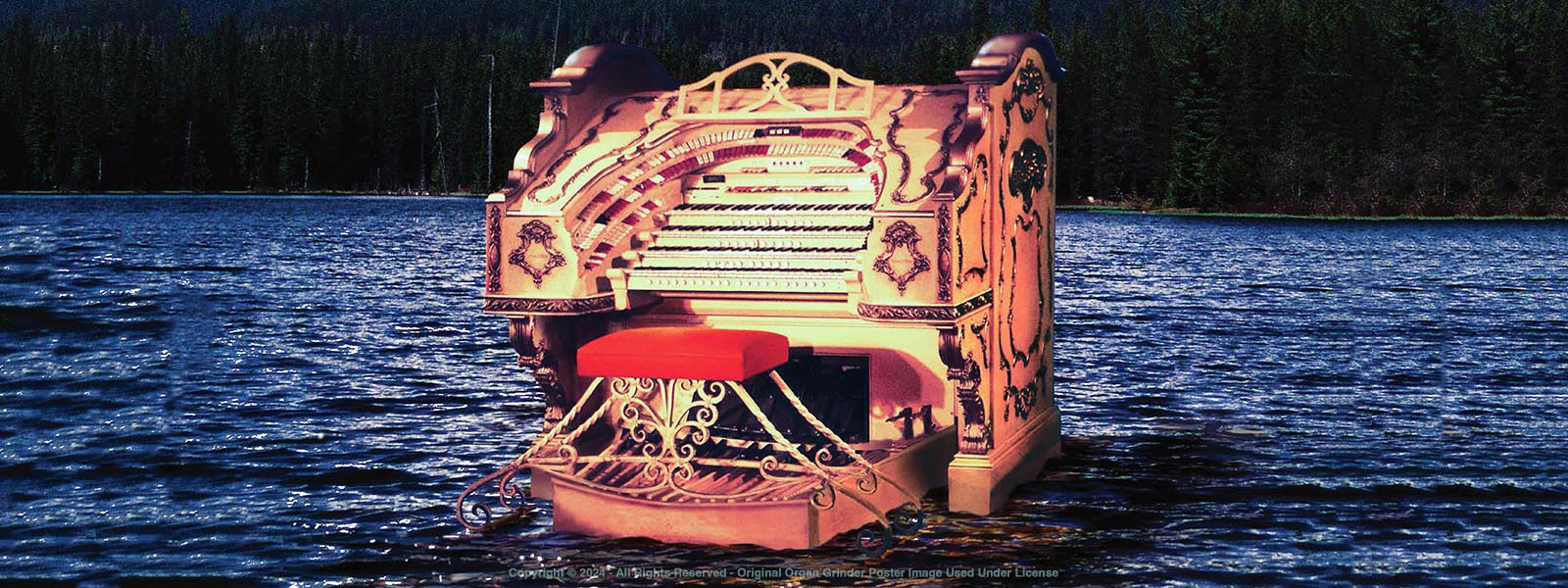 A large, richly decorated 4-manual Wurlitzer organ console sits superimposed on a mountain lake with a forest in the background.